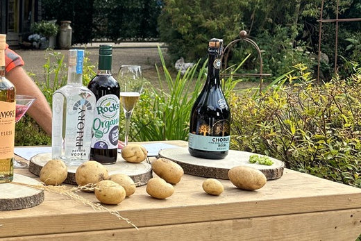 A bottle of Chorus Fine English Sparkling Beer on the harvest table, with a flute beside it